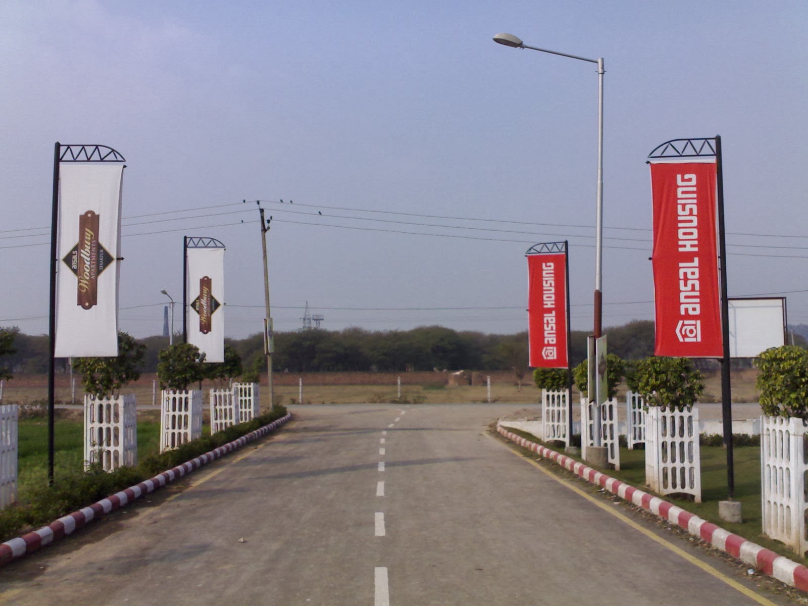 Ansal Housing road banners and flags along a project approach road