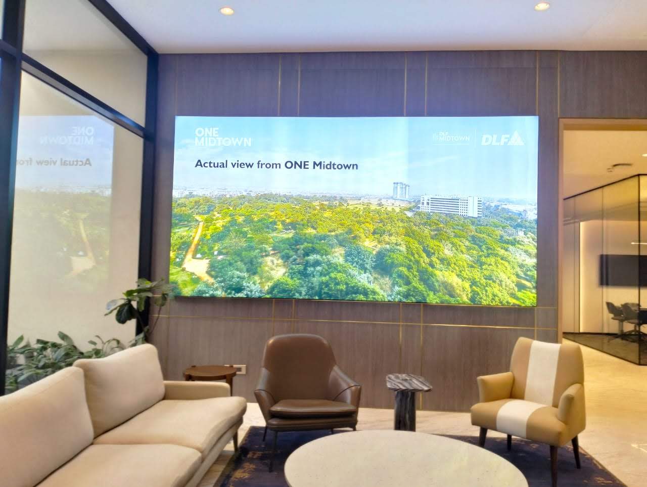 DLF One Midtown experience centre lounge with large backlit brand wall